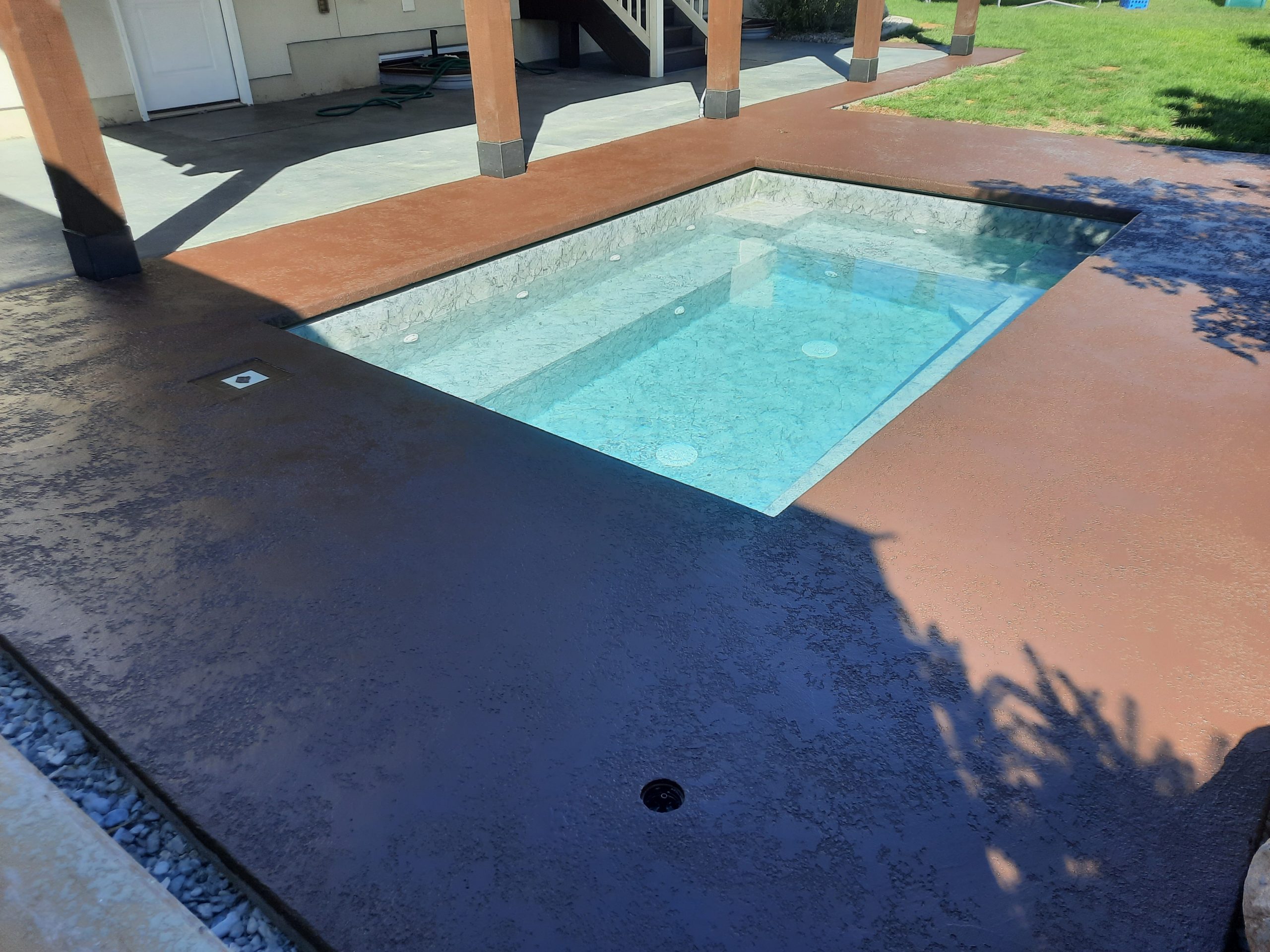 Decorative concrete overlay surrounding an outdoor hot tub in Utah